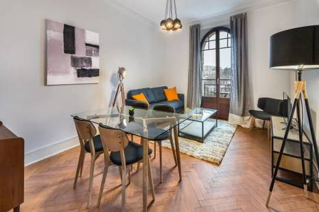 Ce charmant appartement meublé a une décoration qui mêle le bois foncé et la couleur noire pour un effet élégant. Sa ch